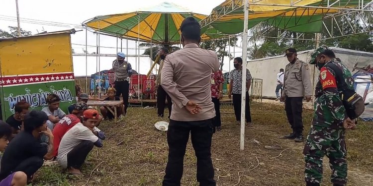 Babinsa Sertu Erna Widayat Dampingi Kapolsek Patia dan Satgas Penanganan Covid-19 Bubarkan Komidi Putar dan Pasar Malam
