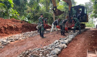 Satgas TMMD Ke-126 Kodim 0601/Pandeglang Lanjutkan Pengerasan Jalan dengan Bantuan Alat Berat Ekskavator, Batu Disebar untuk Dasar yang Kokoh