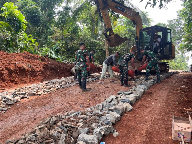 Satgas TMMD Ke-126 Kodim 0601/Pandeglang Lanjutkan Pengerasan Jalan dengan Bantuan Alat Berat Ekskavator, Batu Disebar untuk Dasar yang Kokoh